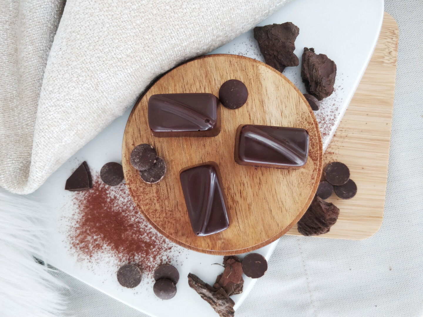 Ganaches de Lio sur un plateau en bois, éclats de chocolat